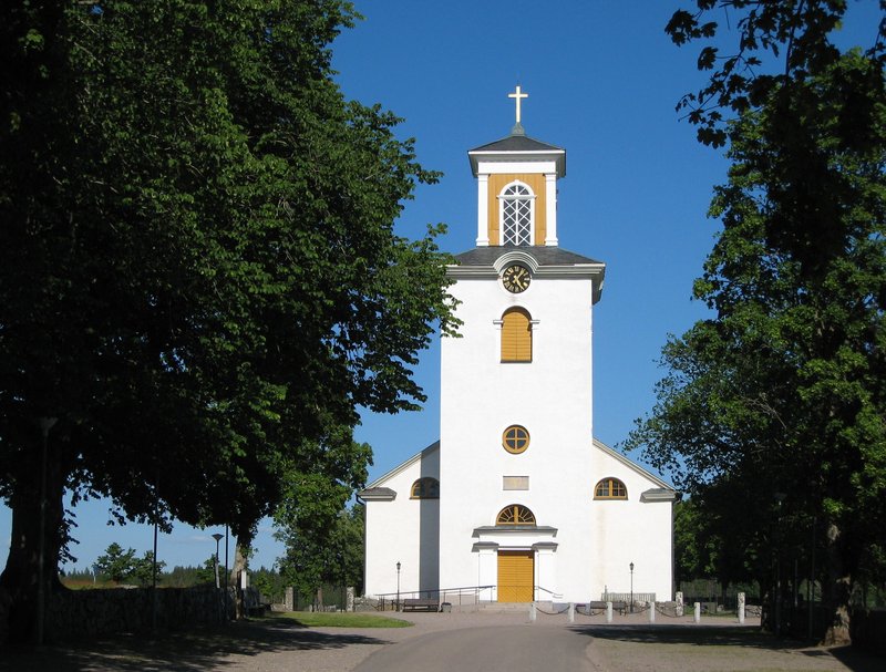 Gårdsby kyrka — en vit kyrka med trädkantad allé
